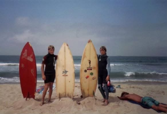 Teenage Marc Mulvaney lying on the sand beside two friends and their surfboards in Huntington Beach, California